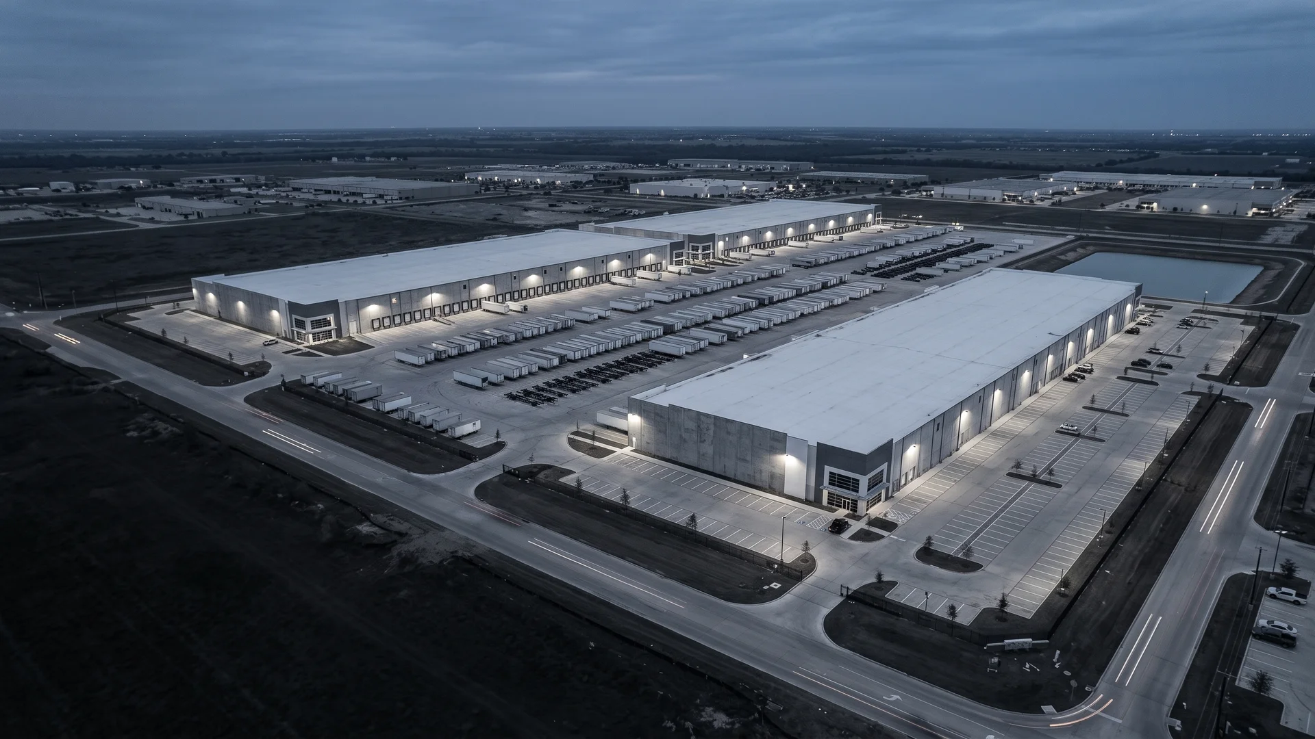Aerial view of a completed light industrial campus at dusk with truck courts and dock doors
